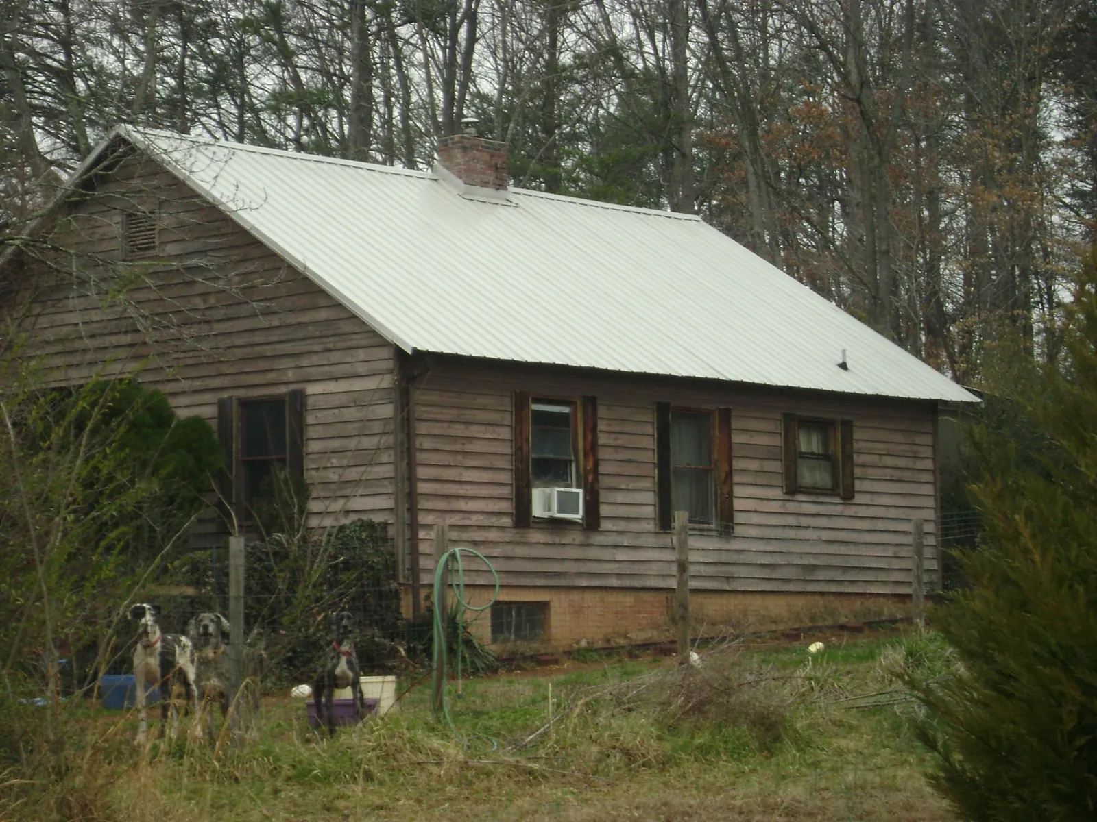 White metal roof on an old wood sided farmhouse, from a Asphalt Shingle Roof Repair job in De Soto